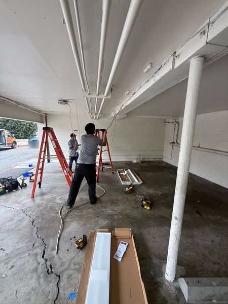 Zion Electric crew installing LED fixtures in a building carport β Zion Electric Inc., San Leandro electrician