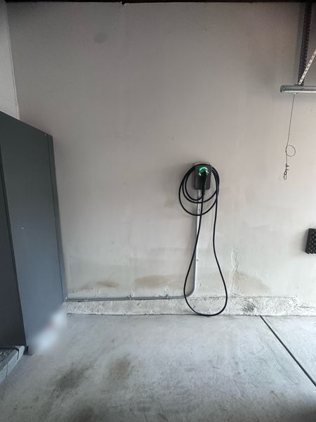 Wall-mounted EV charger in a garage, fed by conduit β Zion Electric Inc., San Leandro electrician