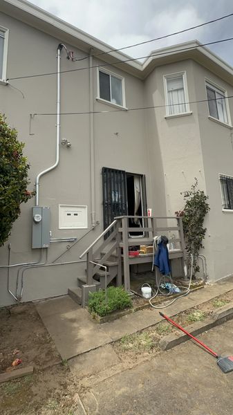 Exterior service upgrade on the back of a home, with new conduit and meter panel β Zion Electric Inc., San Leandro electrician