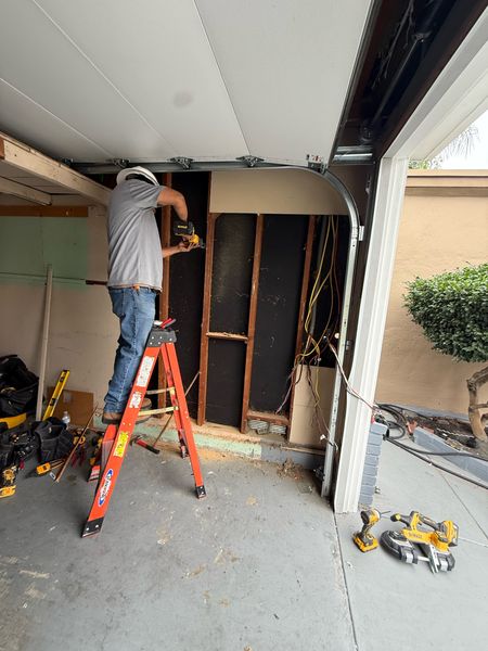 Zion Electric technician drilling from a ladder in a garage – Zion Electric Inc., San Leandro electrician