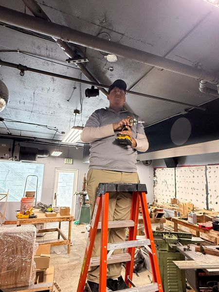 Zion Electric technician working from a ladder in a commercial space – Zion Electric Inc., San Leandro electrician